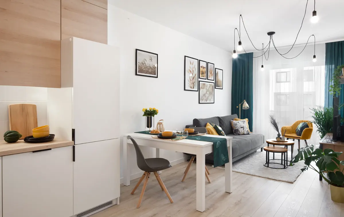 Ten sam salon po home stagingu: zielone zasłony, galeria plakatów